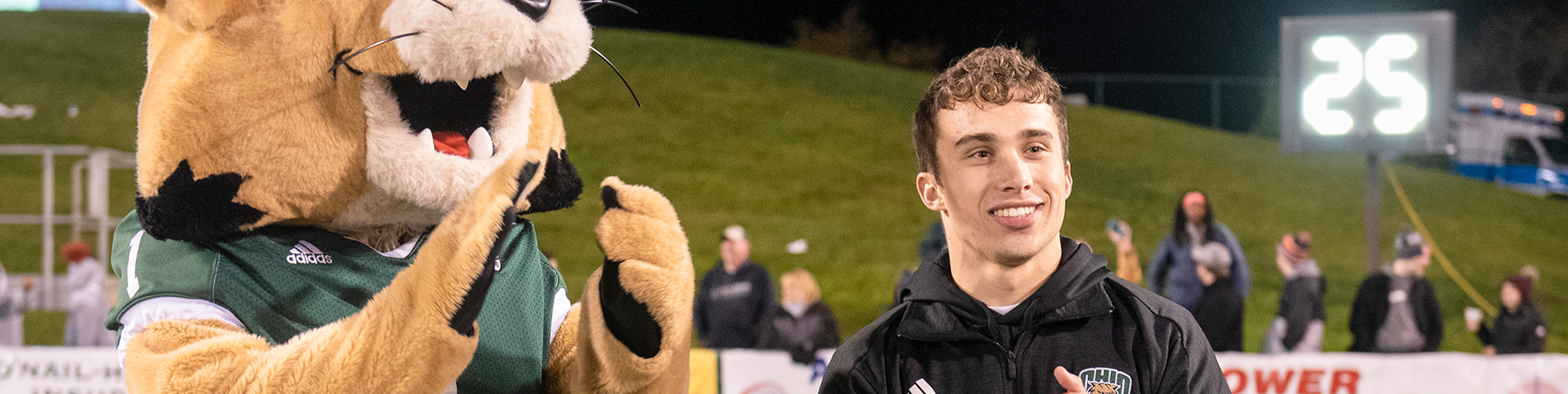 student and mascot at a football game